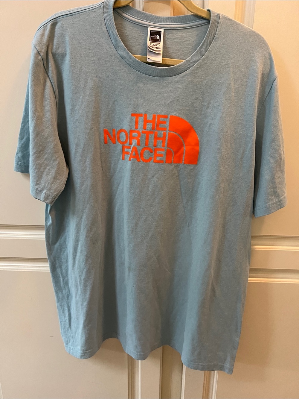 The North Face Men's Short Sleeve Tee in Light Blue with Orange Logo. NWOT